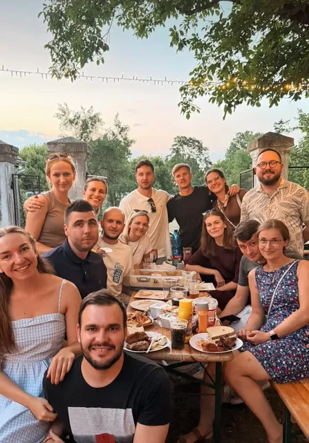 Priatelia pri jedle za stolom v záhrade